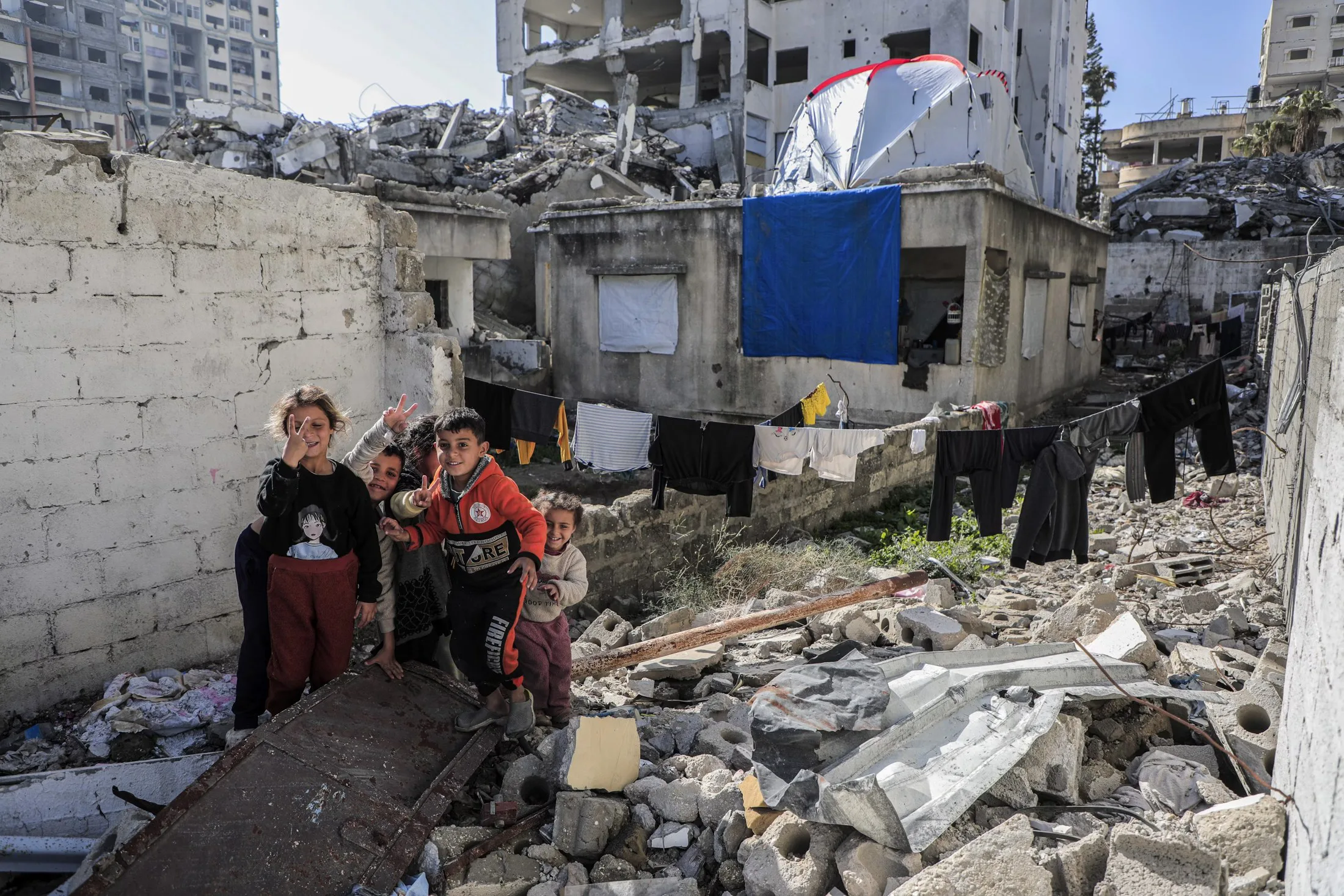 Children smiling together amid the ruins